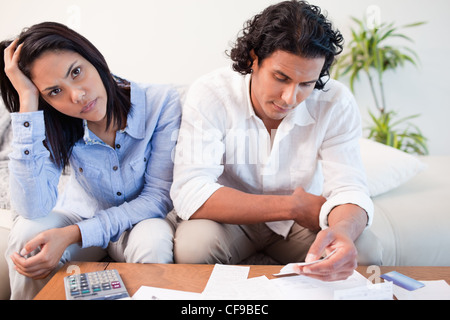 Sad couple checking their bills Stock Photo