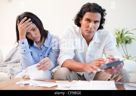 Frustrated couple checking their bills in the living room Stock Photo
