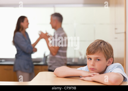 Sad boy hearing his parents having am argument Stock Photo