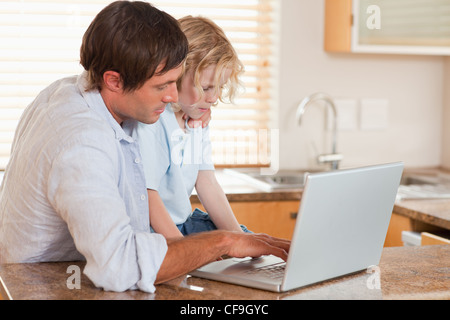Boy and his father using a laptop together Stock Photo