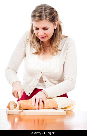 Happy young woman cutting fresh bread, isolated on white background. Stock Photo