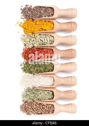Wooden shovels with different spices scattered from them on white background Stock Photo