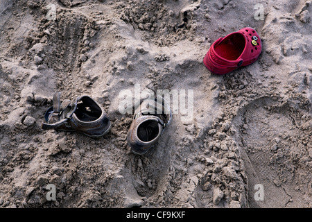 Children's footwear left on sandy beach Stock Photo