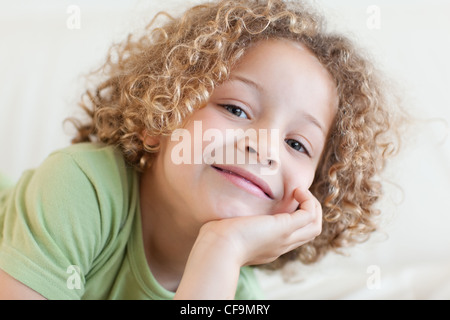 Close up of a smiling boy lying on a sofa Stock Photo