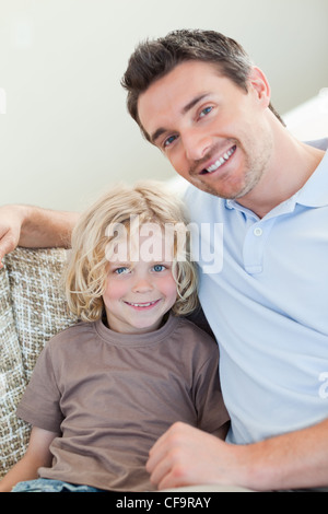 Father and son sitting on sofa Stock Photo