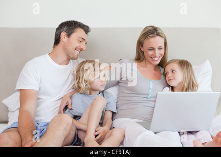 Family using laptop on the bed Stock Photo