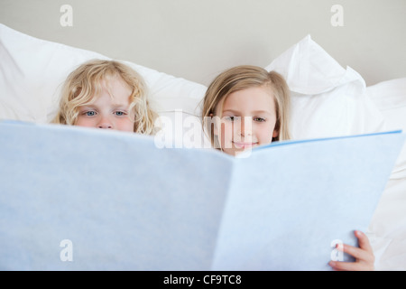 Siblings reading bedtime story Stock Photo