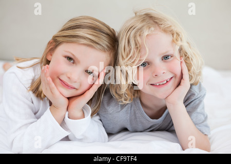 Brother and sister lying on the bed Stock Photo