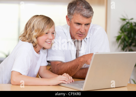 Father and son using laptop in the kitchen Stock Photo