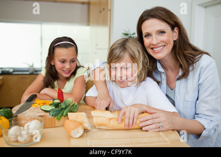 Mother making sandwiches with her children Stock Photo