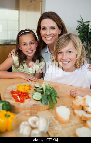 Smiling mother making sandwiches with her children Stock Photo