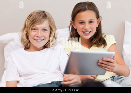 Brother and sister using tablet Stock Photo