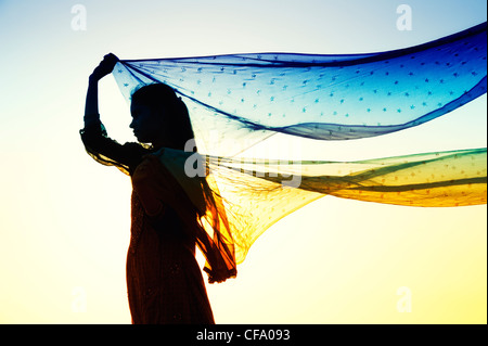 Indian girl with star patterned veils in the wind. Silhouette Stock Photo