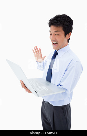 Portrait of a businessman waving at a notebook Stock Photo