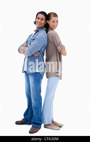Smiling young couple standing back to back Stock Photo