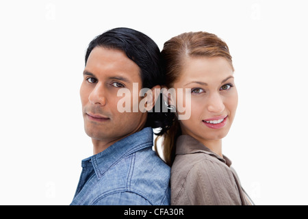 Side view of young couple standing back to back Stock Photo