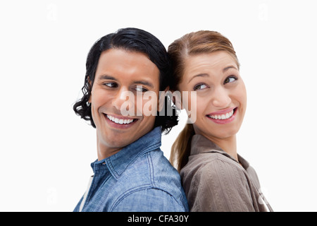 Side view of happy couple standing back to back Stock Photo