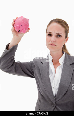 Sad bank employee with empty piggy bank against a white background ...