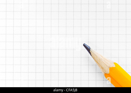 Photo of blank squared graph paper with a yellow pencil, add your own text or diagram. Stock Photo