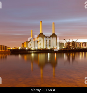 Factory on waterfront lit up at night Stock Photo