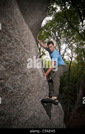 Rock climber scaling boulder Stock Photo