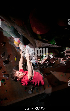 Man climbing indoor rock wall Stock Photo