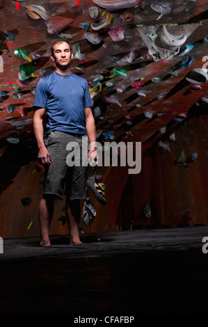 Man standing by indoor rock wall Stock Photo