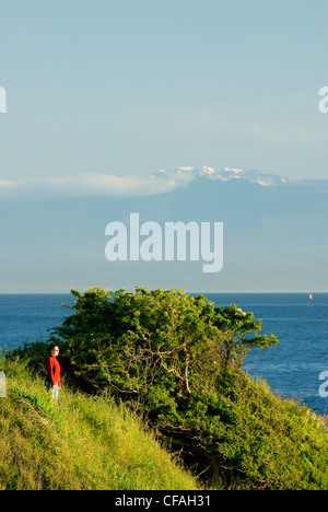 A woman enjoying the view along the Dallas Road waterfront in Victoria, Vancouver Island, British Columbia, Canada. Stock Photo