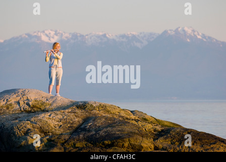 woman playing flute beach along Dallas Road Stock Photo