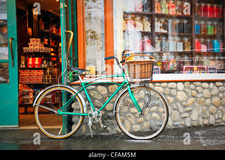 Cruiser bicycle with basket parked outside a Candy Store during a snowfall. Banff, Alberta, Canada. Stock Photo