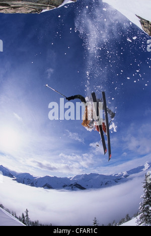 A skier catching some air after jumping a cliff in the backcountry of Kickinghorse Resort Area, Golden, British Columbia, Canada
