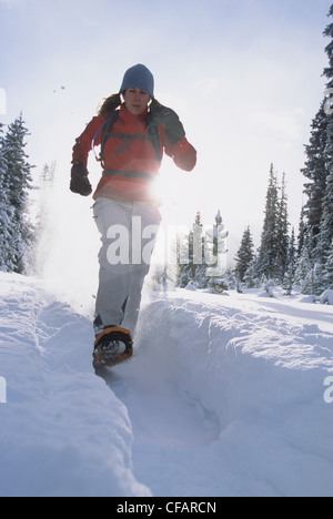 A young female snowshoer enjoying a winter morning run in Kananaskis Country, Alberta, Canada Stock Photo