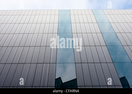 Sky detail on windows of office building shows an artistic and interesting architectural aspect to contemporary corporate design