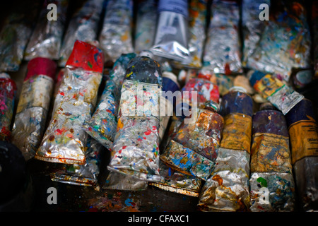Metallic tubes of oil paint that have been opened and used in a pile Stock Photo