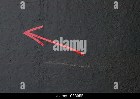 red arrow on black wall Stock Photo