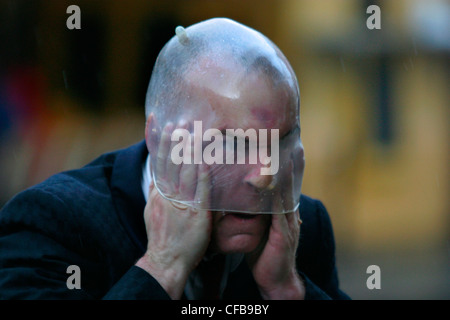 A performance artist in Covent Garden with a condom on his head, london Stock Photo