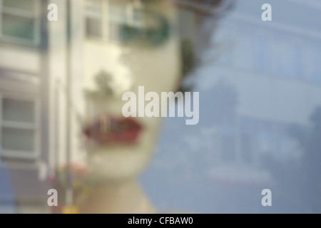 Reflection of poster of woman's face in a window, London, UK. Stock Photo