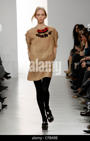 Marni Milan Ready to Wear Autumn Winter Burgundy zip up cape jacket over  sack dress, black footless tights, leather and fur Stock Photo - Alamy