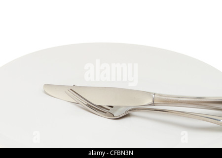 Closeup of a stainless steel knife and fork on a plate Stock Photo