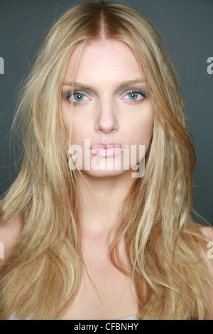 Burberry Milan Backstage Spring Summer Blonde female model with very long wavy hair, grey eyeshadow and pale pink lips Stock Photo