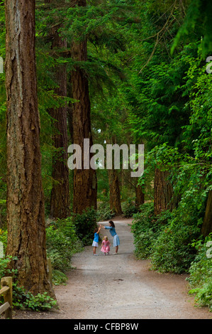Mother and daughters on path to Lighthouse Park, West Vancouver, British Columbia, Canada Stock Photo