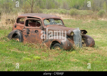 Rusty old car sitting in a field in Ramara Township, Ontario, Canada. Stock Photo