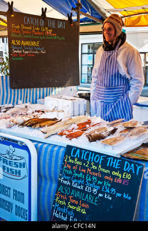Fishmonger behind a fresh fish stall in the Market Square, Cambridge, England, UK Stock Photo