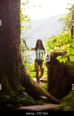 A young woman walks back from the beach after windsurfing, Nitinat Lake, Vancouver Island, BC Stock Photo