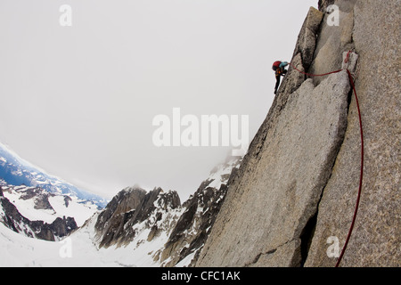 A female climber ascends the Northeast Ridge - North Howser, Bugaboos, BC Stock Photo