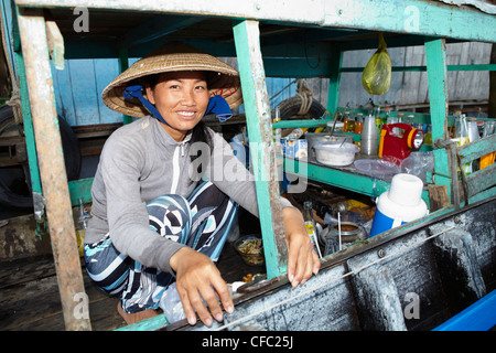 Young woman sells drinks at a floating market at Cai Rang, (Can Tho) Vietnam Stock Photo