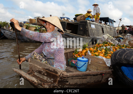 Smiling woman paddles through a floating market at Cai Rang, (Can Tho) Vietnam Stock Photo