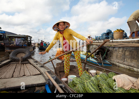 A woman steers through boats at a floating market at Cai Rang, (Can Tho) Vietnam Stock Photo