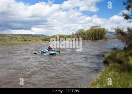 A man rafts down a river on a beautiful day in Montana. Stock Photo