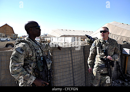 LOGAR PROVINCE, Afghanistan – (L-R) Master Sgt. Douglas Brown, the senior career counselor for 3rd Brigade Combat Team, 1st Armored Division talks to Sgt. 1st Class Jeremy K. Schwanke, a native of Newport News, Va., prior to boarding the CH-46 Chinook helicopter for his fourth and final reenlistment at Forward Operating Base Shank. Schwanke, the military police operations NCO for the brigade, recently submitted his aviation warrant officer packet and hopes to become a helicopter pilot. Stock Photo